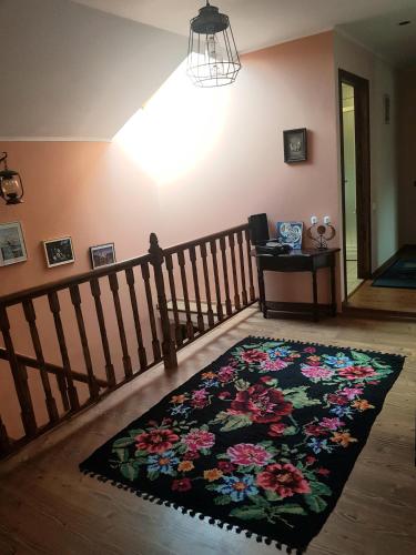 a living room with a flower rug on the floor at Vila Magnolia in Curtea de Argeş