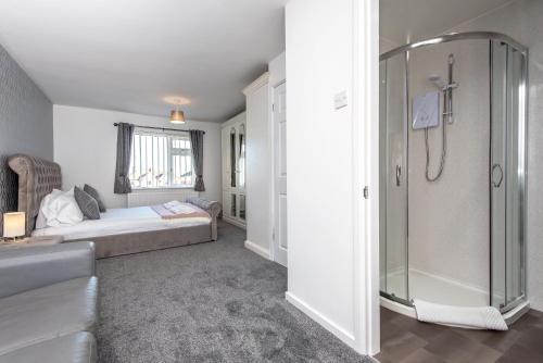 a bathroom with a shower and a bed in a room at Park Drive in Langley Park