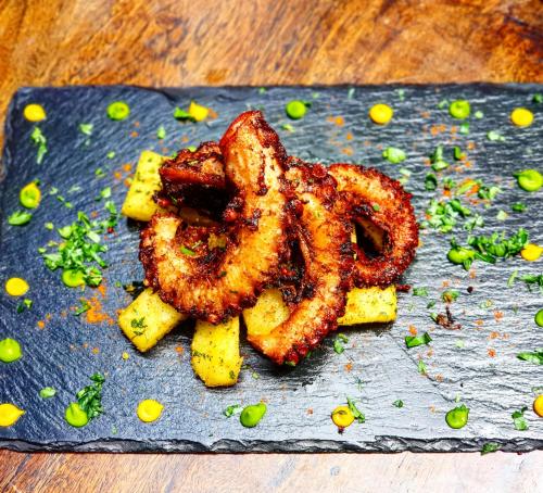 a plate of food with onion rings on a table at Boutique Hotel Matlai in Michamvi