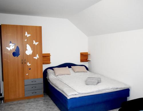 sypialnia z łóżkiem i drewnianą szafką w obiekcie Apartment Kolman w Bohinju