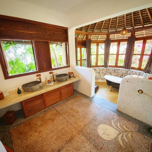 a bathroom with two sinks and a couch at Boutique Hotel Matlai in Michamvi