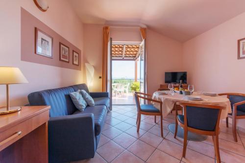 a living room with a table and a couch and a dining room at Loano 2 Village in Loano
