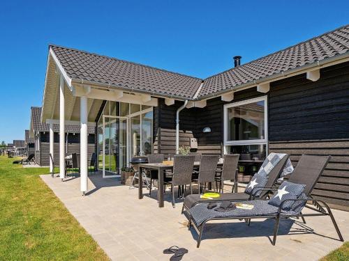 a patio with chairs and a table on a house at 12 person holiday home in Hasselberg in Kappeln