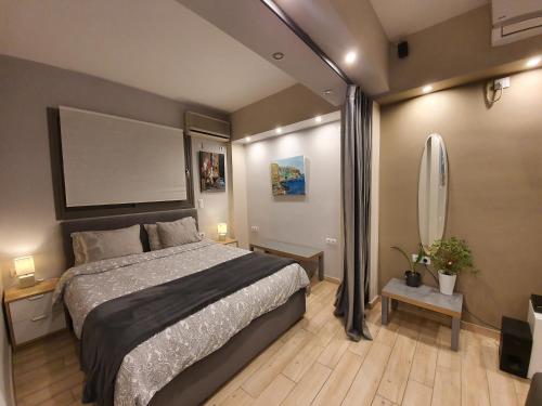 1 dormitorio con 1 cama grande y una tabla en blanco en la pared en Super Loft With Acropolis View, en Atenas