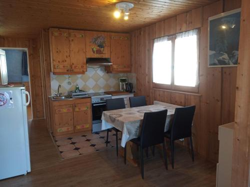 a kitchen with a table and chairs and a refrigerator at Appartement Daria in Prémanon