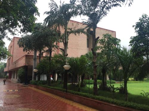 a building with palm trees in front of it at The Radha Ashok in Mathura