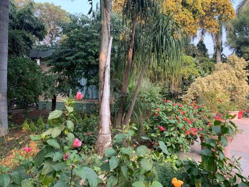 a garden with flowers and a tree in a park at The Radha Ashok in Mathura