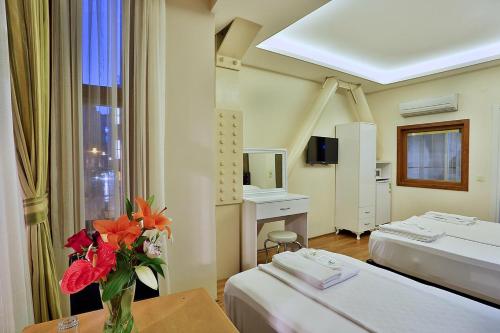 a hospital room with two beds and a vase of flowers at Gh Suites Taxim Hotel in Istanbul