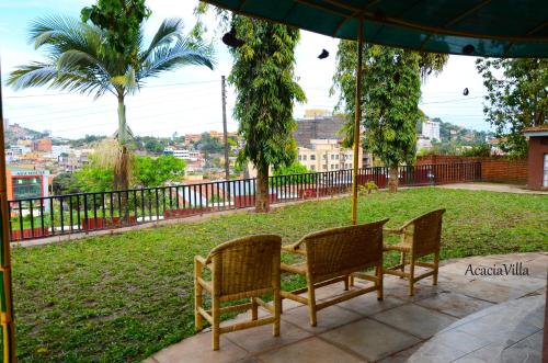 two chairs and an umbrella on a patio at Acacia Villa Kampala in Kampala