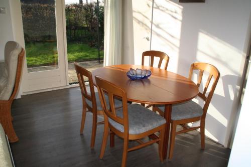 a dining room table and chairs with a window at Rekerlanden 154 in Schoorldam