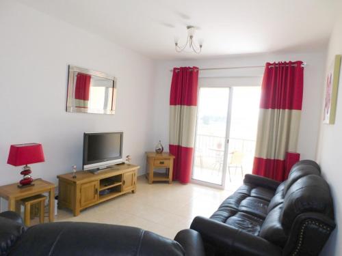 a living room with a couch and a television at Excellent 2 bed Apartment in Mandria