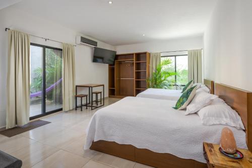 a bedroom with a large bed and a large window at Stay Tropical in Cancún