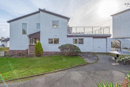 a large white house with a patio and a yard at Carnedd - Trearddur Bay - Stanley-Stays in Trearddur