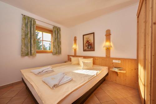 a bedroom with a bed with two towels on it at Appartement Hotel Sonneck in Königsleiten