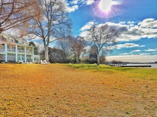 a house on a field with the sun in the sky at Sandaway Suites & Beach in Oxford