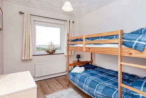a bedroom with two bunk beds and a window at Carnedd - Trearddur Bay - Stanley-Stays in Trearddur