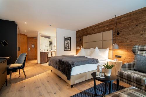 a hotel room with a bed and a couch at Walliserhof Grand-Hotel & Spa Relais & Châteaux in Saas-Fee