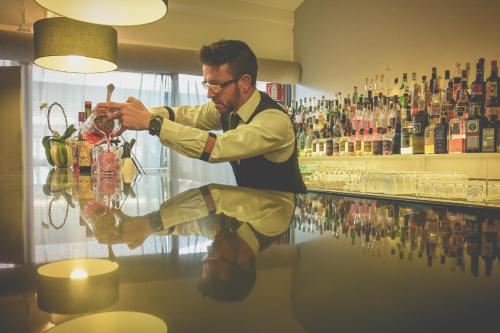 a man standing at a bar making a drink at Loano 2 Village in Loano