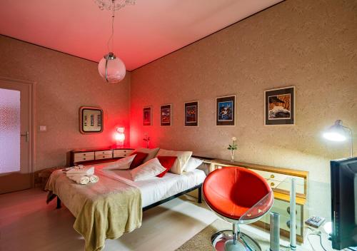 um quarto com uma cama e uma parede vermelha em 70's Lovers Apartment in Turin em Turim