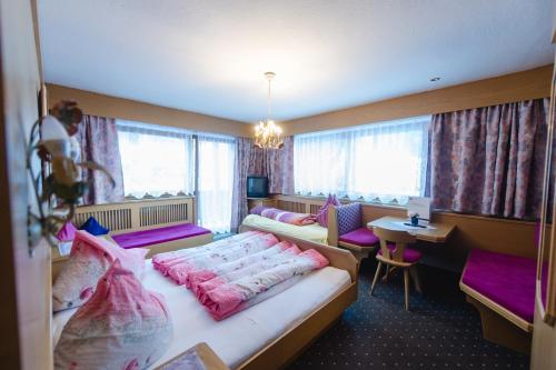 a hotel room with two beds and a desk at Alpenheim Simone in Sölden