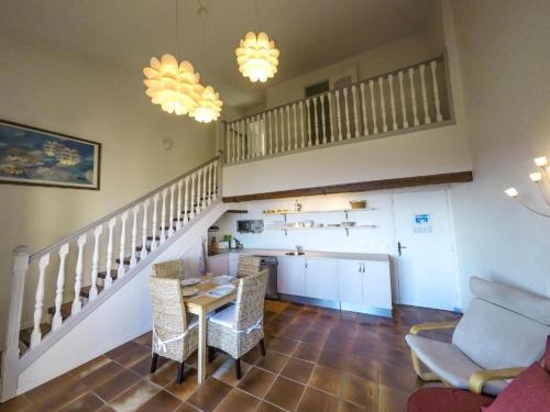 a living room with a staircase and a table and chairs at Domaine du Bois d'Amont in Cabris
