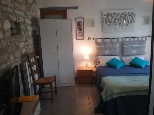 a bedroom with a bed and a table and a chair at Le Luberon Lou Mas Li Pitchoun in Gordes