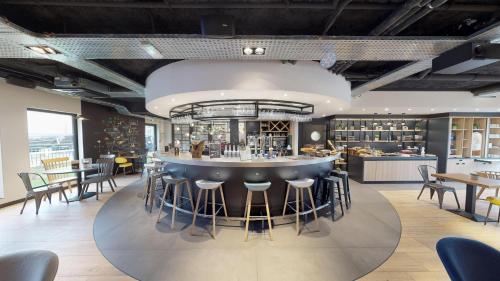 a bar in a restaurant with chairs and tables at Campanile Fontainebleau in Fontainebleau