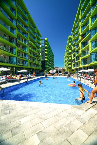 a group of people in a swimming pool with buildings at Alezzi Beach Resort in Mamaia Nord