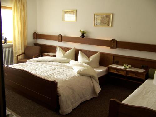 a hotel room with a large bed with white pillows at Gästehaus Rachelblick in Frauenau