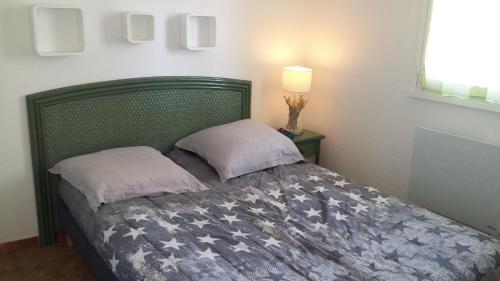 une chambre avec un lit avec deux oreillers dessus dans l'établissement Appartement 3 Pièces wifi Plage Richelieu CAP D'AGDE, au Cap d'Agde