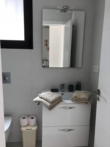 a white bathroom with a sink and a mirror at Villa Bianco in Orihuela Costa