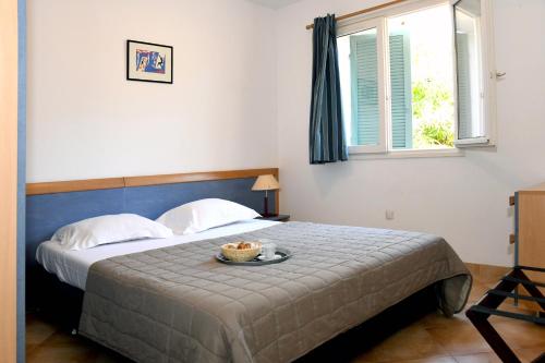 a bedroom with a bed with a bowl of food on it at Résidence Cala Bianca in Borgo