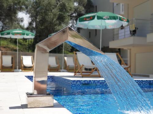 a water slide in a pool with an umbrella at GREJM Family Apartments in Petrovac na Moru