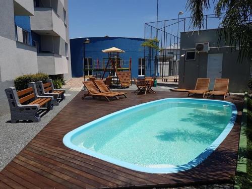 una piscina en una terraza con sillas y un parque infantil en Apartamento novo Próximo ao Parque Beto carreiro, en Penha
