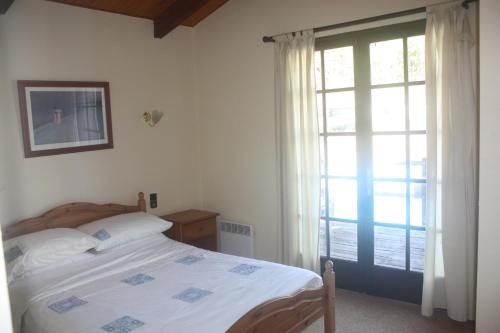 ein Schlafzimmer mit einem Bett und einem großen Fenster in der Unterkunft Maison-Limoux Chambre D'Hote Limoux 11300 in Limoux