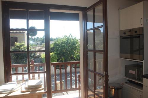 eine Küche mit offener Tür zum Balkon in der Unterkunft Maison-Limoux Chambre D'Hote Limoux 11300 in Limoux