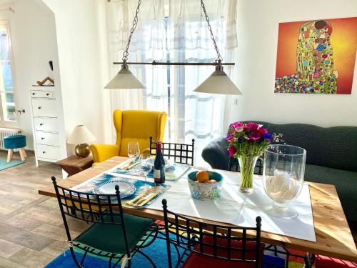 un salon avec une table et des chaises ainsi qu'une salle à manger dans l'établissement Traumhafte Ferienwohnung Nuages in der Villa-Fontaine-Vieille, Vence, Nähe Nizza, à Vence