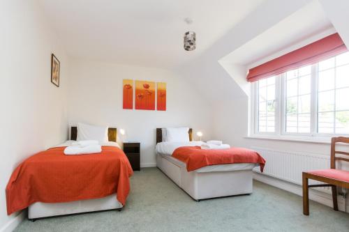 a white room with two beds and a window at Lake Cottage in Thorpeness