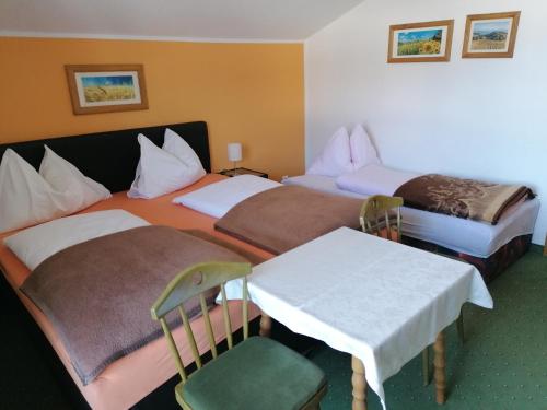 um quarto de hotel com duas camas e uma mesa em Haus Anneliese em Gröbming