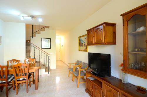a living room with a dining table and a television at TARRACO 25 (GIRONES) in L'Estartit