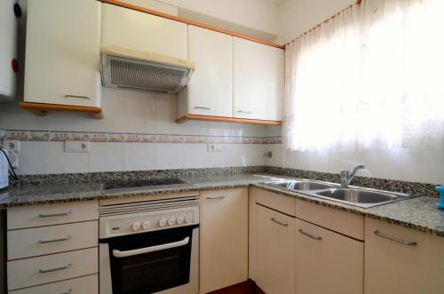a kitchen with white cabinets and a sink at TARRACO 25 (GIRONES) in L'Estartit