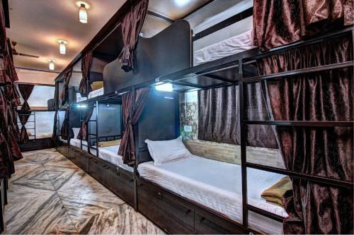 kilka łóżek piętrowych w pokoju w obiekcie Sunshine Backpackers, Airport w Bombaju