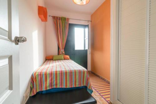 a small bedroom with a bed and a window at MIRADOR DEL VALLE in Vélez de Benaudalla