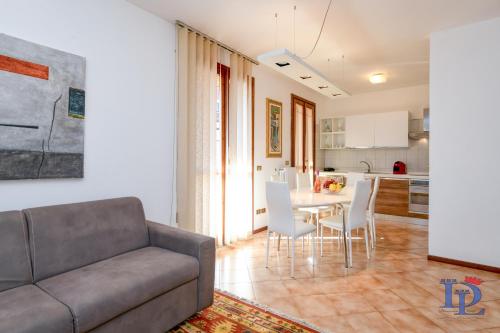 ein Wohnzimmer mit einem Sofa, einem Tisch und Stühlen in der Unterkunft DesenzanoLoft Enjoy in Desenzano del Garda