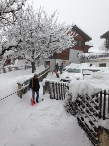 a person walking through a yard covered in snow at Casa Schuoler in Disentis