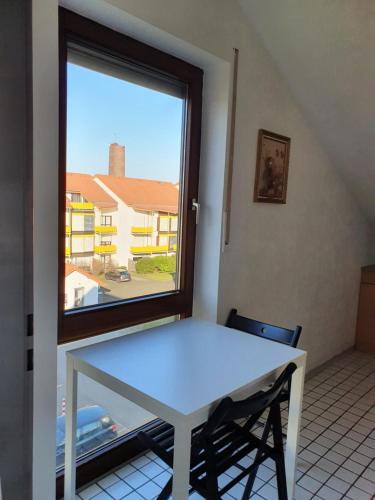 een witte tafel in een kamer met een raam bij Beautiful City Apartment für bis 4 Personen in Paderborn