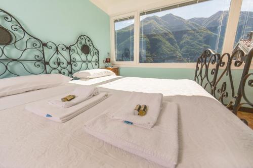 a bedroom with a bed with towels and a window at Albergo Diffuso Ca' Spiga in Laglio