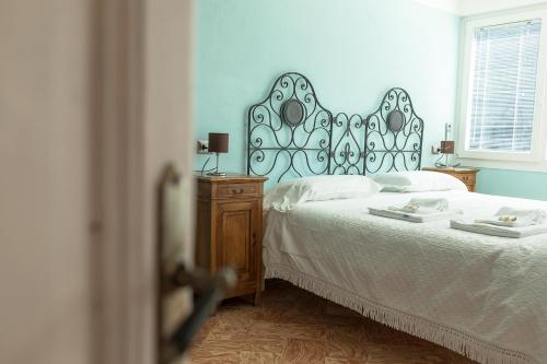 a bedroom with a bed with a black and white headboard at Albergo Diffuso Ca' Spiga in Laglio