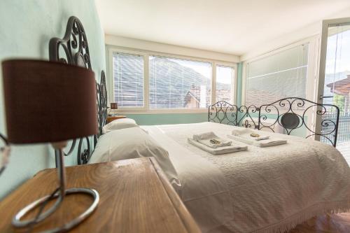 a bedroom with a bed with a table and a chair at Albergo Diffuso Ca' Spiga in Laglio