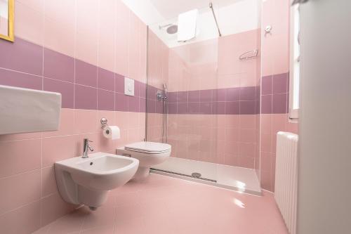 een roze badkamer met een toilet en een wastafel bij Albergo Diffuso Ca' Spiga in Laglio
